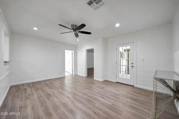 an empty room with wooden floor and windows