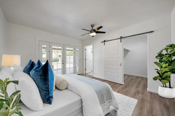 a spacious bedroom with a bed and a potted plant