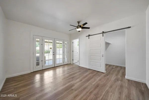 a view of an empty room with a window and wooden floor