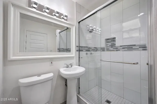 a bathroom with a sink mirror toilet and shower