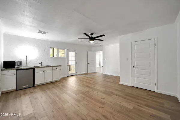 a view of a kitchen with wooden floor and a sink