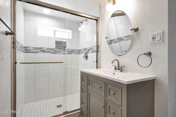 a bathroom with a double vanity sink mirror and shower