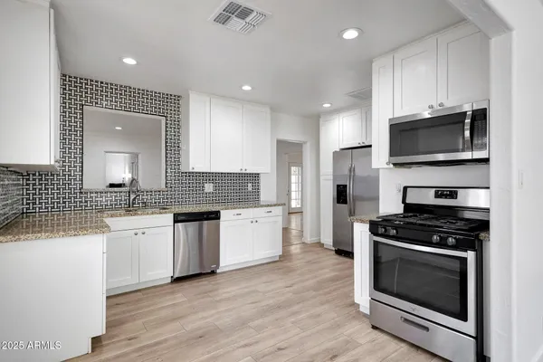a kitchen with a sink stove top oven and cabinets
