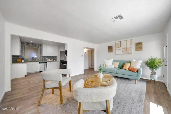 a living room with furniture and a wooden floor