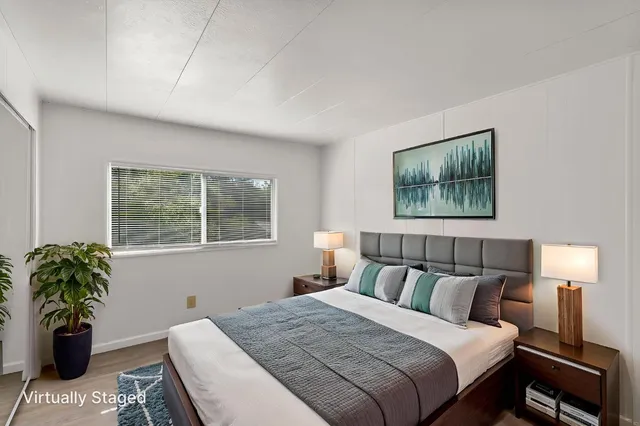 a bedroom with a bed and a painting on the wall