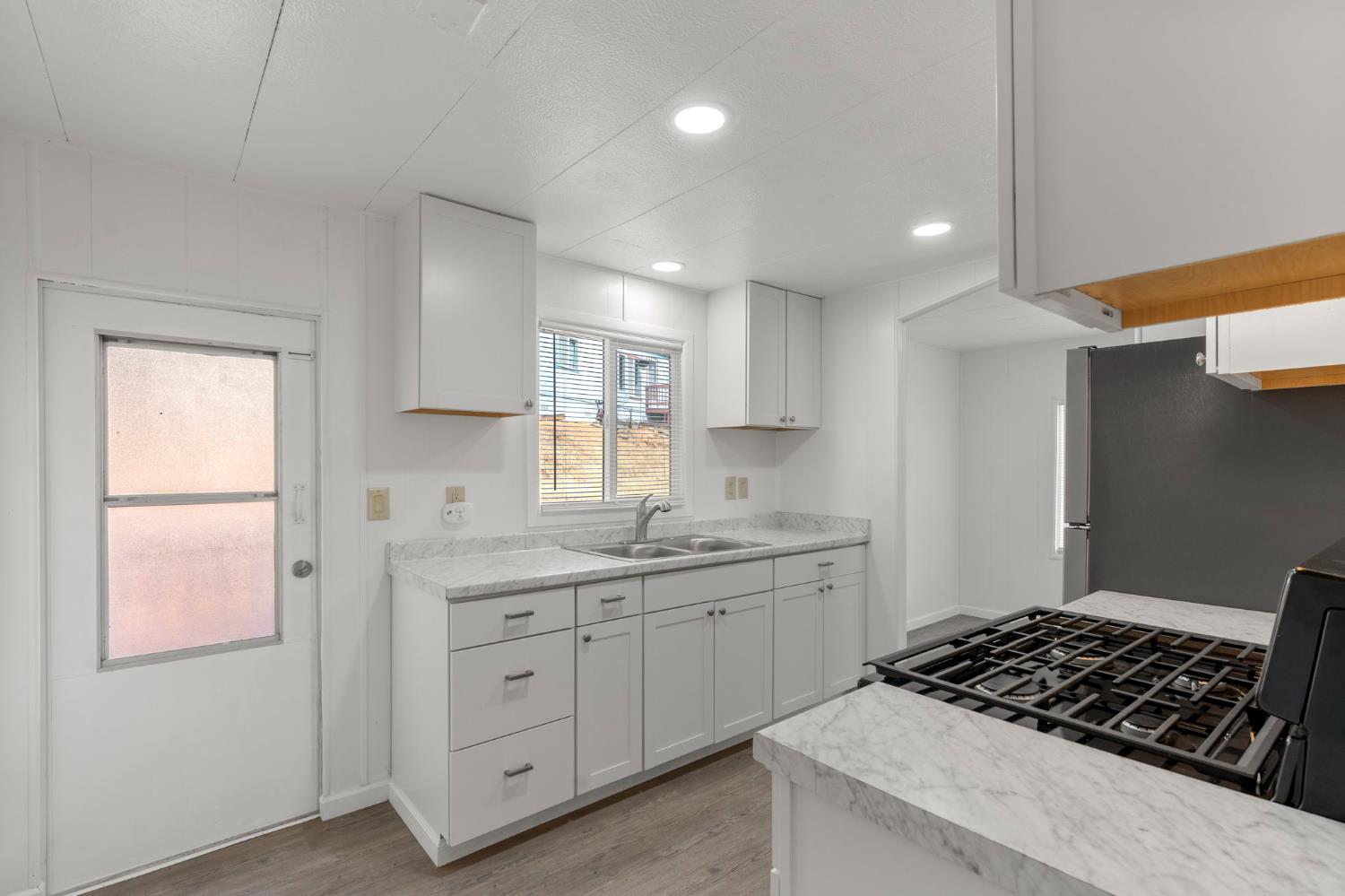 10155 Peppermint Circle, Unit 35 Jamestown, CA 95327 - Photo 8 of 27 a kitchen with white cabinets and a stove