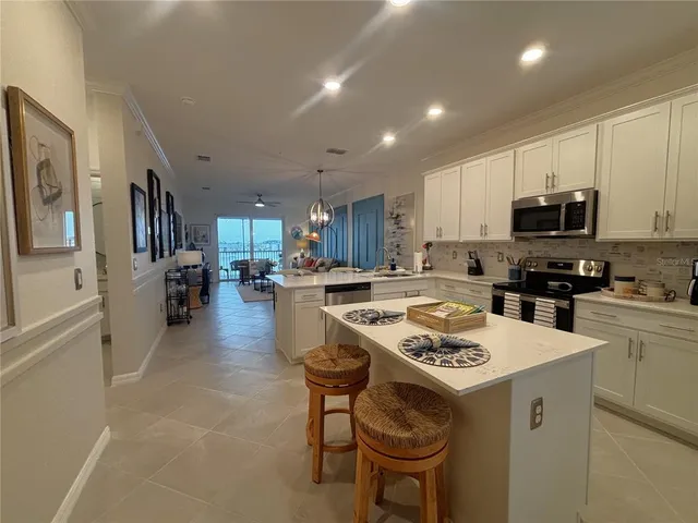 a kitchen with a sink a stove a refrigerator and a dining table with wooden floor