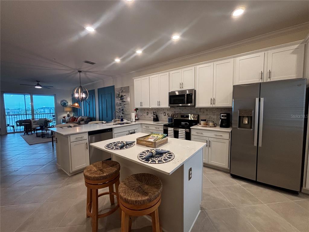 12140 Wellen Golf Street, Unit 404 Venice, FL 34293 - Photo 4 of 55 a kitchen with a sink a stove a refrigerator and a dining table with wooden floor