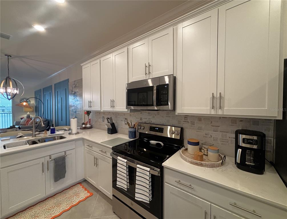 12140 Wellen Golf Street, Unit 404 Venice, FL 34293 - Photo 5 of 55 a kitchen with a sink a stove and cabinets