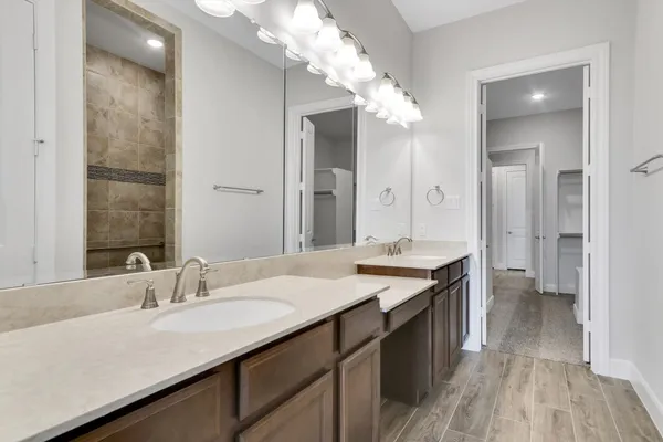 a bathroom with a granite countertop sink a large mirror and a shower
