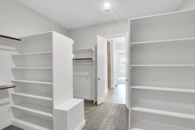 a view of walk in closet with empty racks