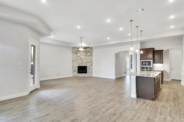a view of kitchen with stainless steel appliances kitchen island granite countertop a refrigerator and a stove top oven