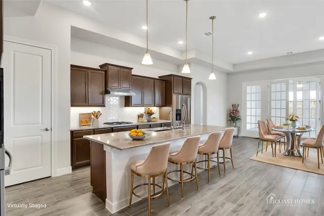 a kitchen with a dining table chairs refrigerator and cabinets