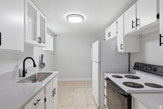 629 King Circle Layton, UT 84041 - Photo 17 of 26 Kitchen featuring white cabinetry with matte black hardware, a black pull-down faucet, a stainless steel undermount sink, and light-toned tile flooring
