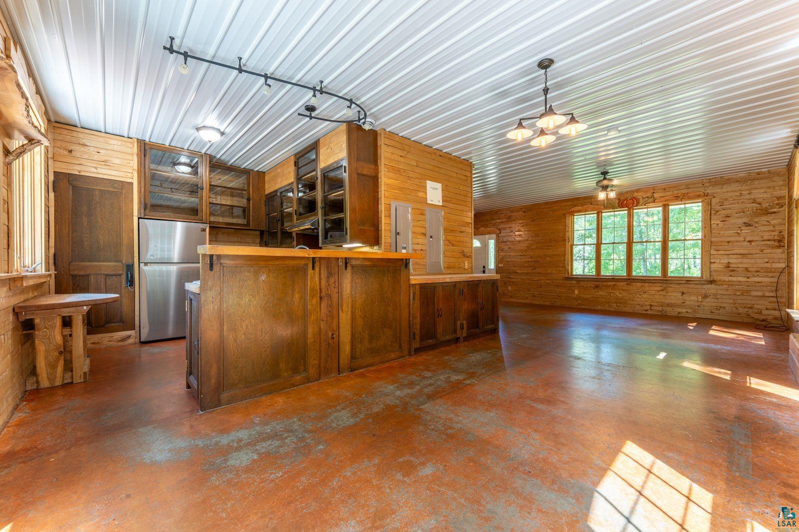 9734 Alango Road Angora, MN 55703 - Photo 6 of 41 Spacious interior featuring wood-finish walls and concrete flooring