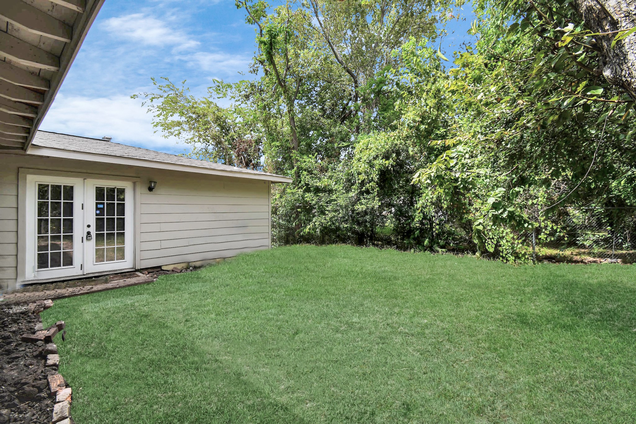 3743 Odin Court Houston, TX 77021 - Photo 32 of 36 A thick carpet of green grass stretches across the rear grounds, bordered by natural foliage to create a vibrant space for weekend relaxation.