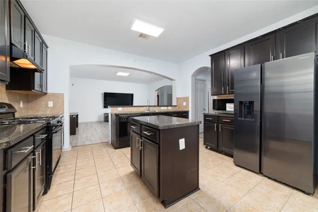 a kitchen with stainless steel appliances granite countertop a stove a refrigerator and a oven