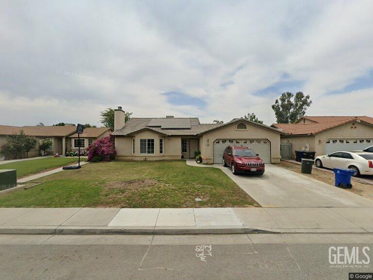 a view of a big house with a big yard and large trees