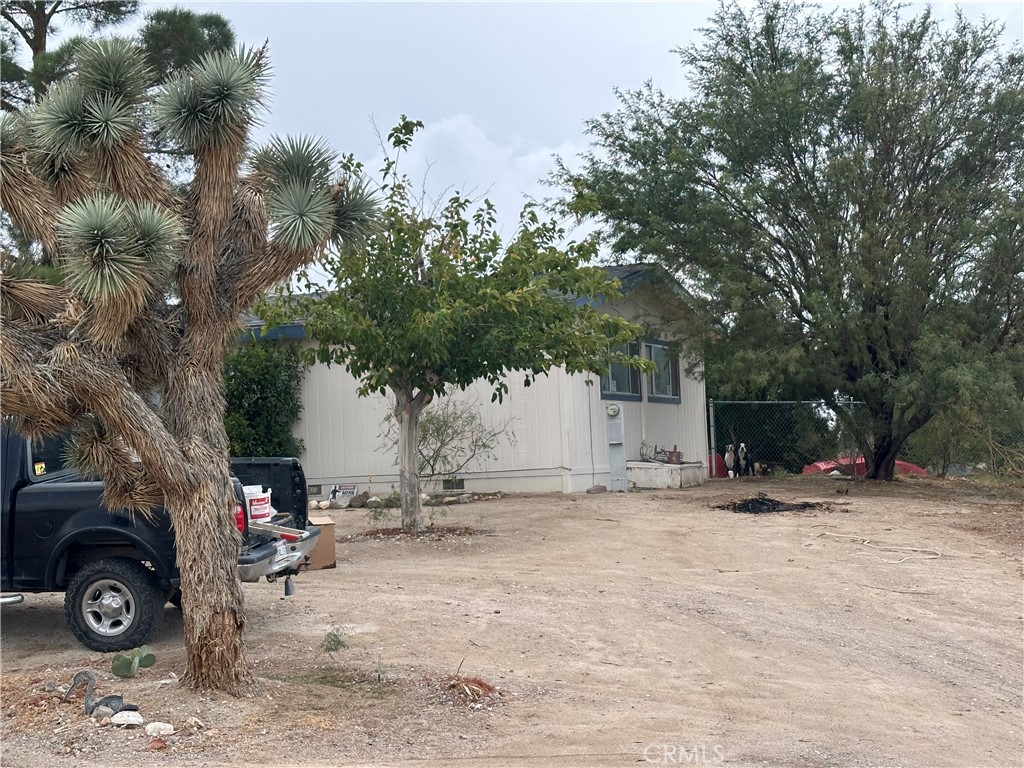 9372 Mesa Road Lucerne Valley, CA 92356 - Photo 3 of 3 a view of a backyard with table and chairs and a large tree