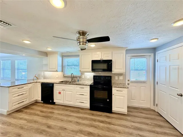 a view of kitchen with sink microwave and refrigerator