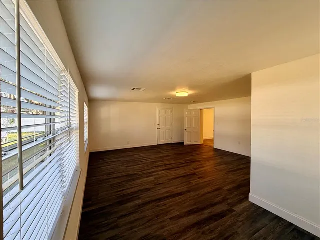 a view of empty room with window and ceiling fan
