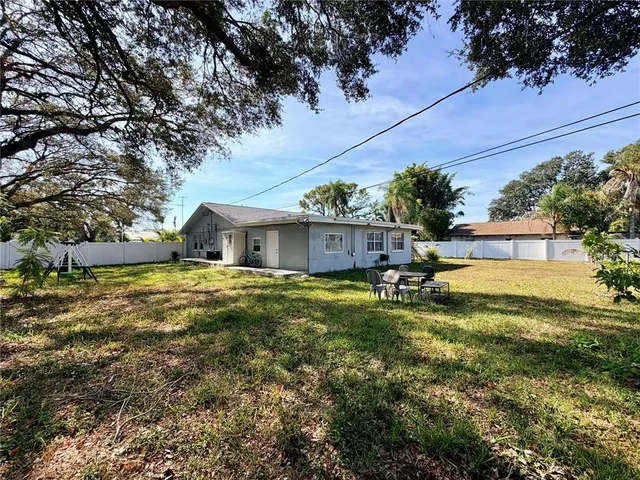 a view of a house with a yard and potted plants