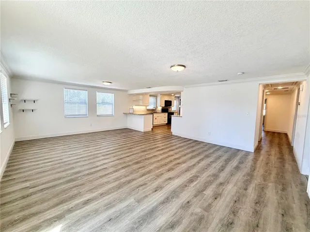 a view of a big room with wooden floor and windows
