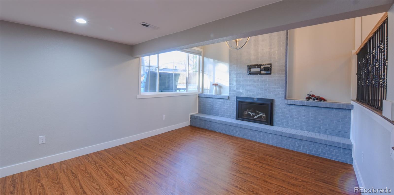 5389 West Roxbury Place Littleton, CO 80128 - Photo 16 of 31 a view of an empty room with wooden floor and a window