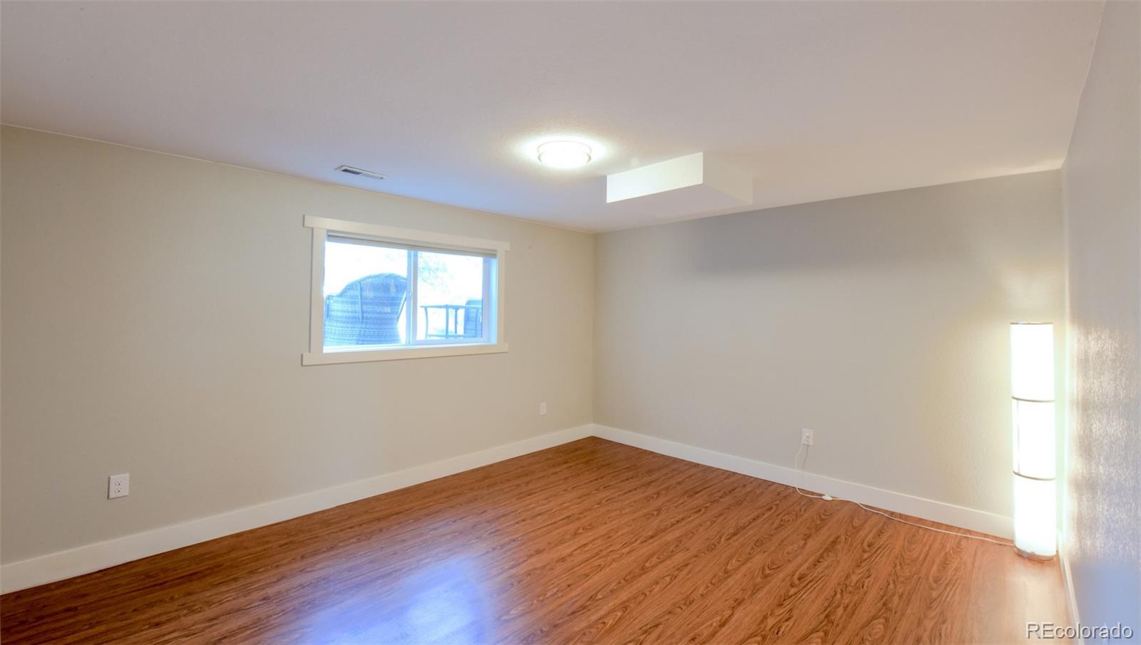 5389 West Roxbury Place Littleton, CO 80128 - Photo 18 of 31 a view of empty room with wooden floor and fan