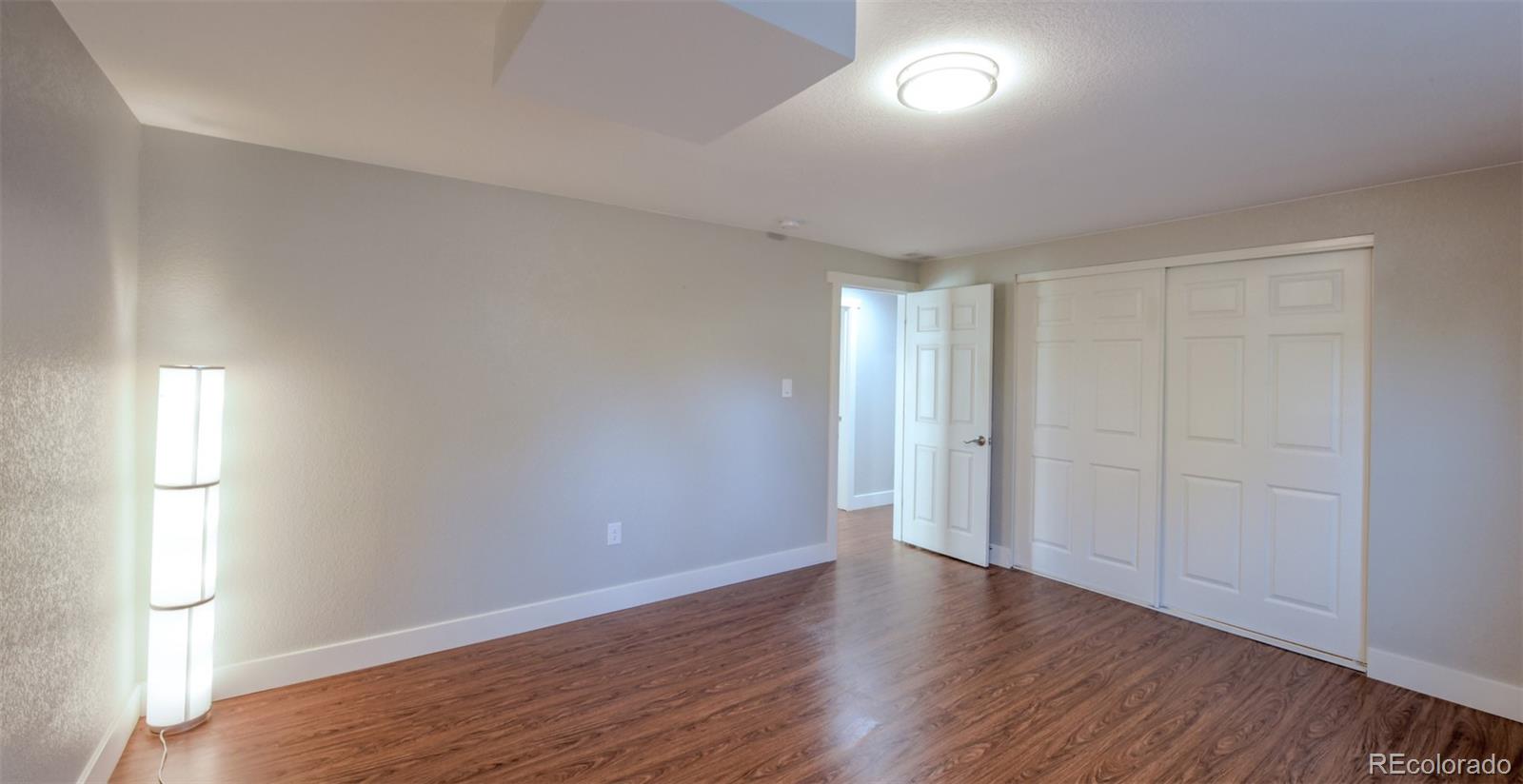 5389 West Roxbury Place Littleton, CO 80128 - Photo 19 of 31 an empty room with wooden floor and windows