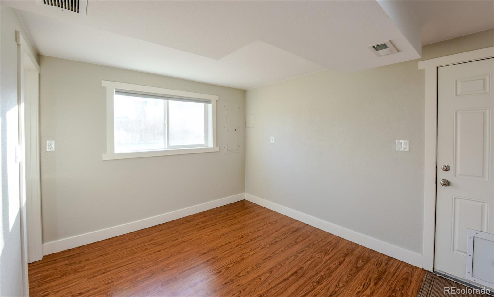 5389 West Roxbury Place Littleton, CO 80128 - Photo 22 of 31 an empty room with wooden floor and windows