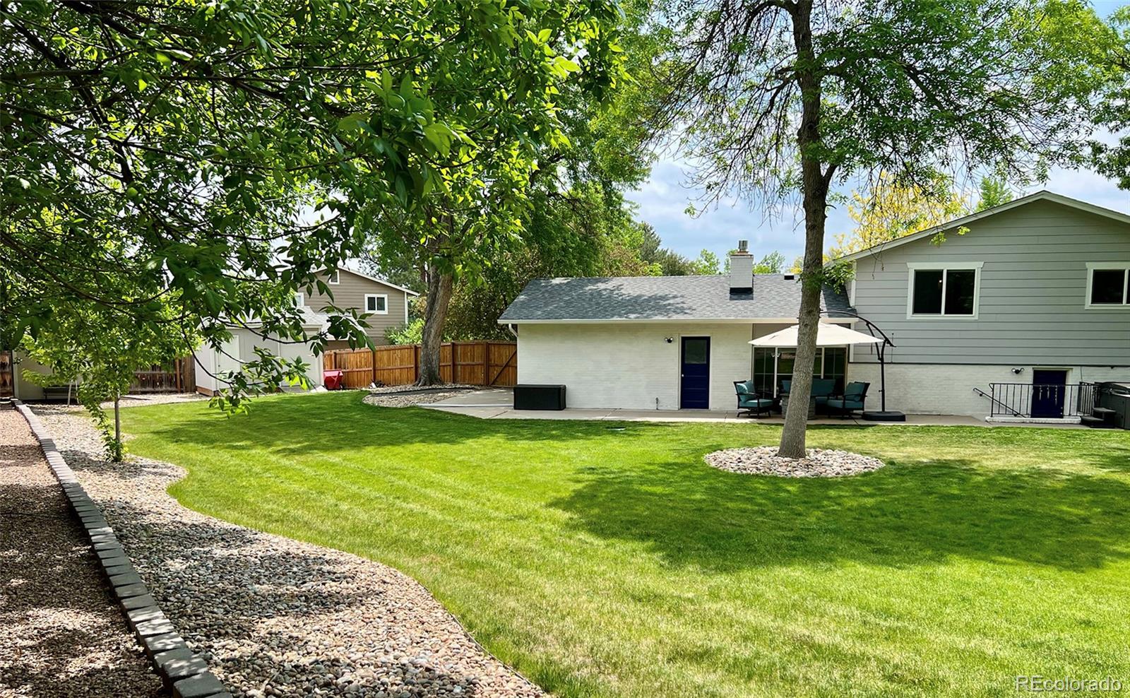 5389 West Roxbury Place Littleton, CO 80128 - Photo 25 of 31 a front view of a house with a garden and trees