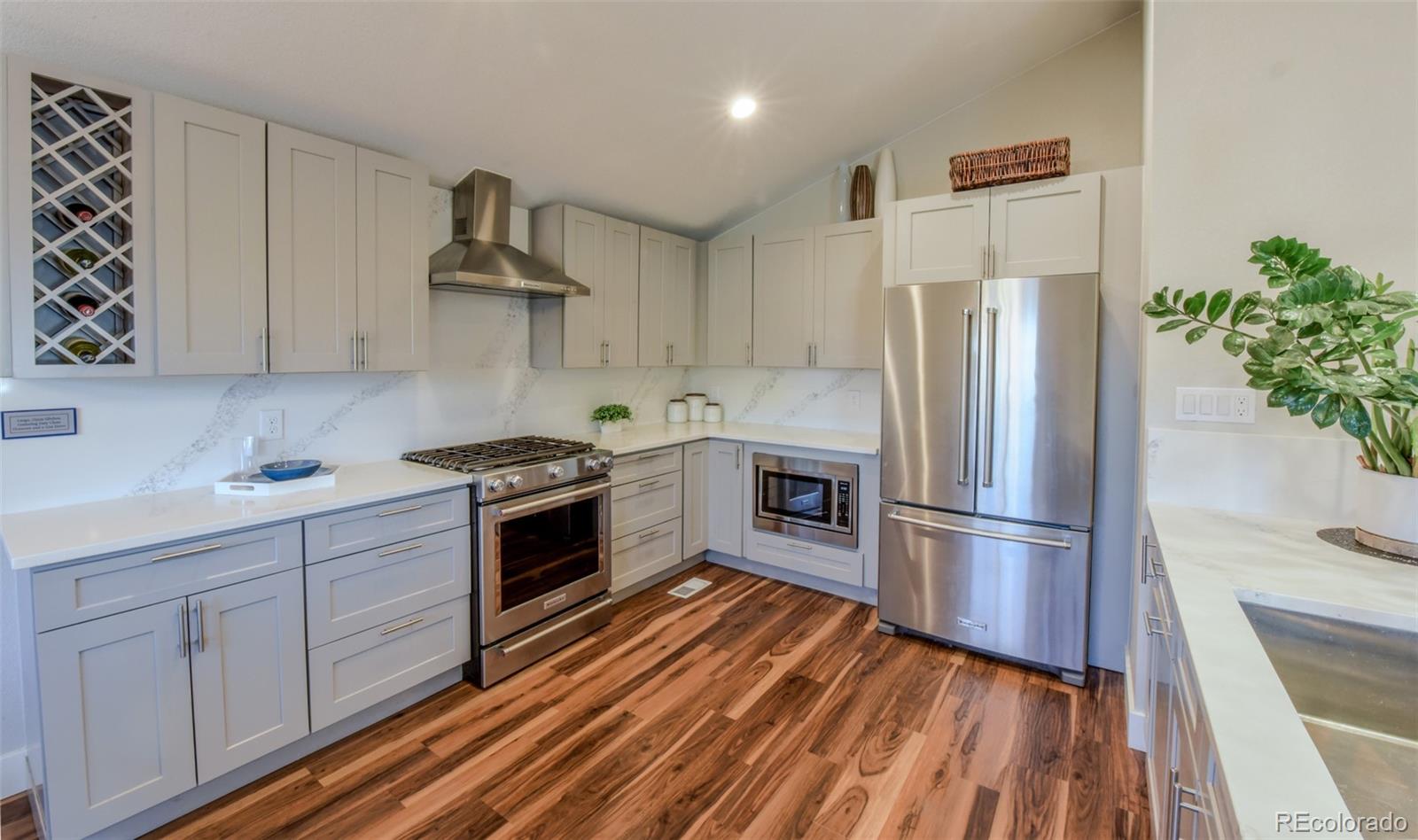 5389 West Roxbury Place Littleton, CO 80128 - Photo 7 of 31 a kitchen with wooden floors and stainless steel appliances