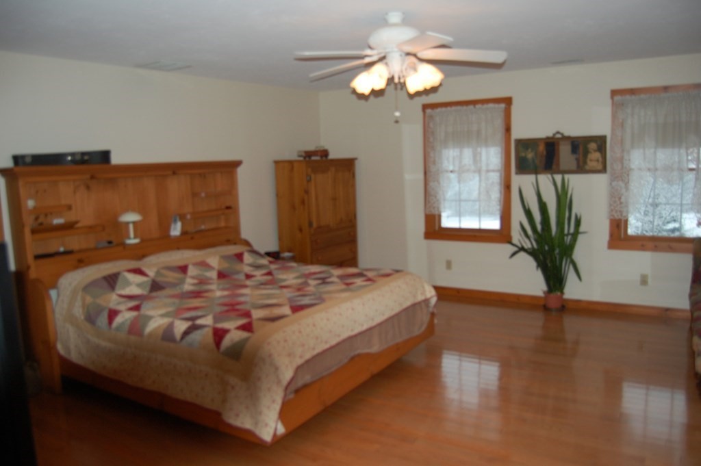 215 Crouch Road Warren, MA 01092 - Photo 16 of 33 a bedroom with a large bed chandelier and a flat tv screen on dresser