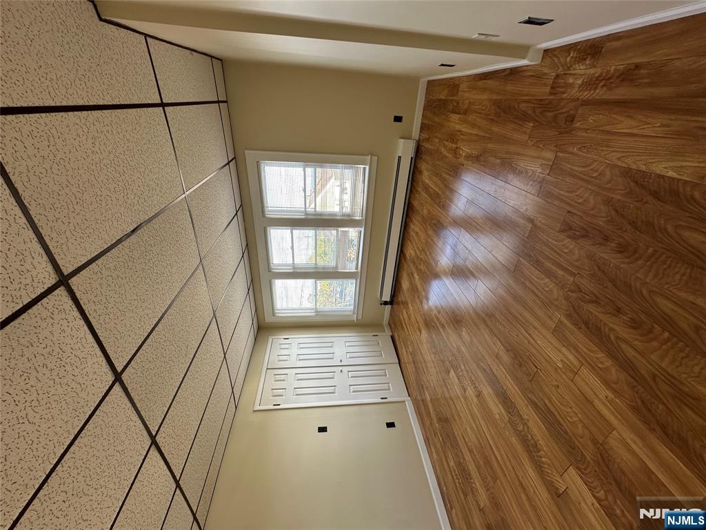 a view of a room with wooden floor and windows