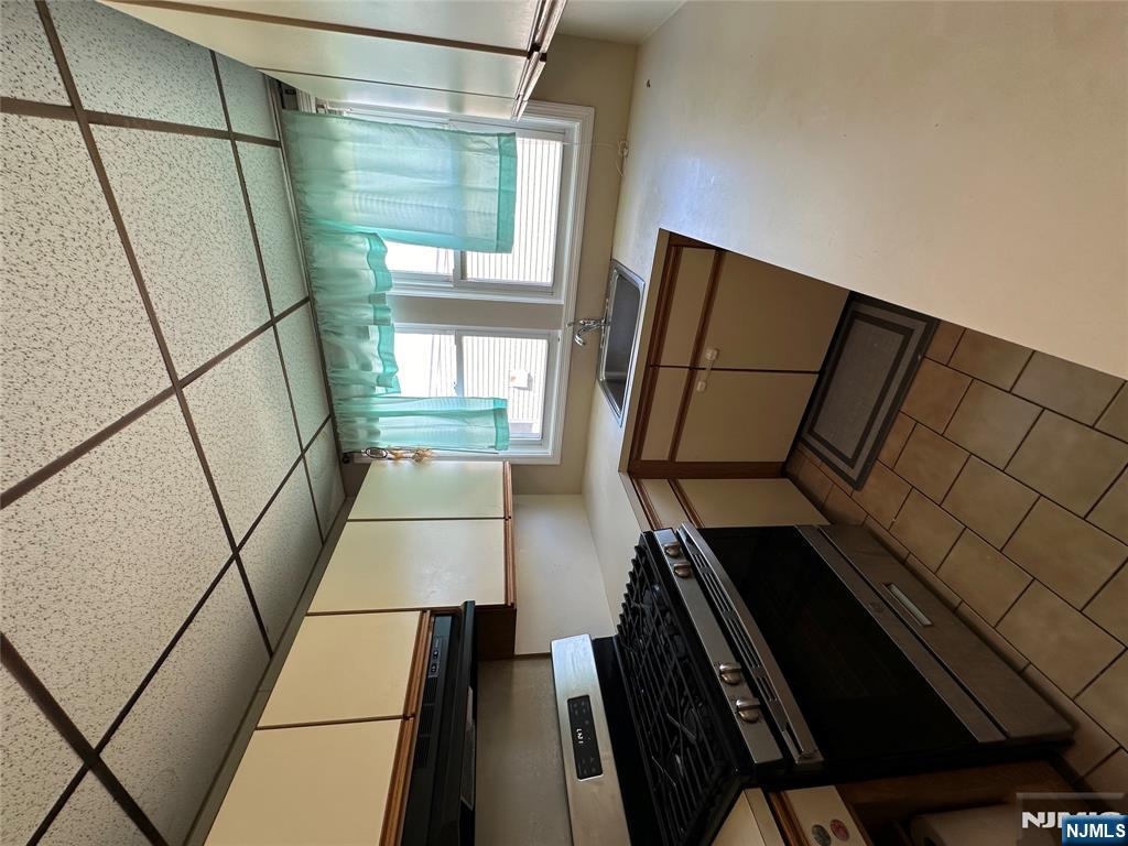 622-624 8th Street, Unit 2L Lyndhurst, NJ 07071 - Photo 18 of 23 a kitchen with stainless steel appliances granite countertop a stove a sink dishwasher and a microwave