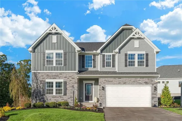 a front view of a house with a garden and yard
