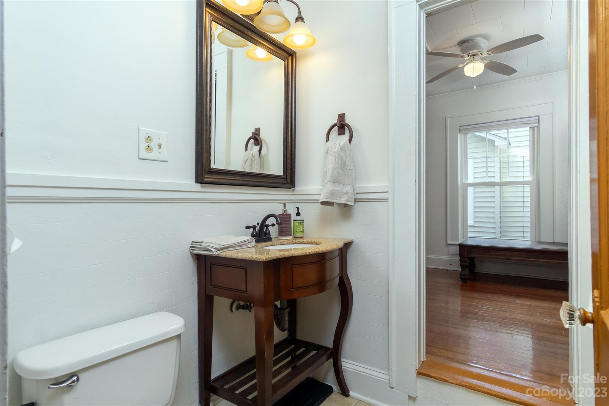 404 Huffman Street Morganton, NC 28655 - Photo 17 of 27 a bathroom with a toilet a sink and a window