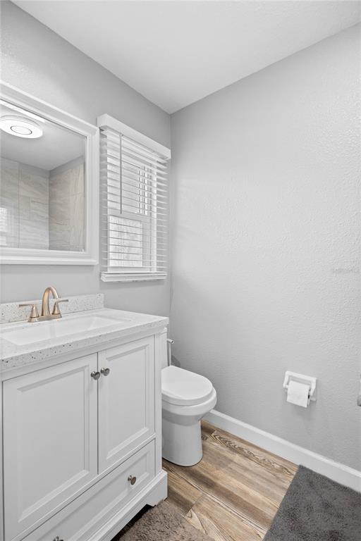 3801 42nd Street West Bradenton, FL 34205 - Photo 19 of 34 a bathroom with a granite countertop toilet a sink a mirror and a window
