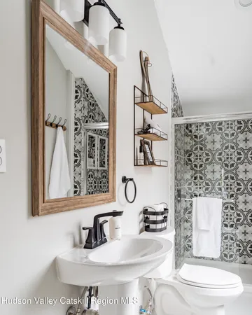 a bathroom with a toilet sink and mirror