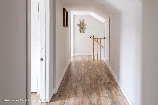 a view of a hallway with wooden floor and staircase