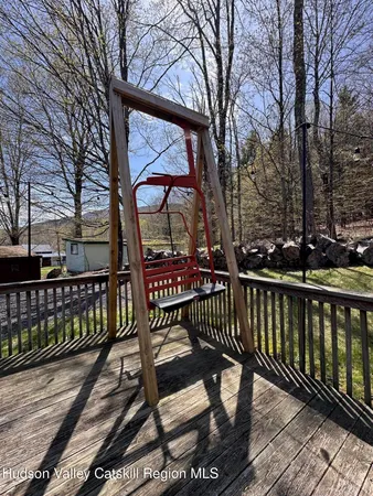 a view of a house with wooden deck and furniture