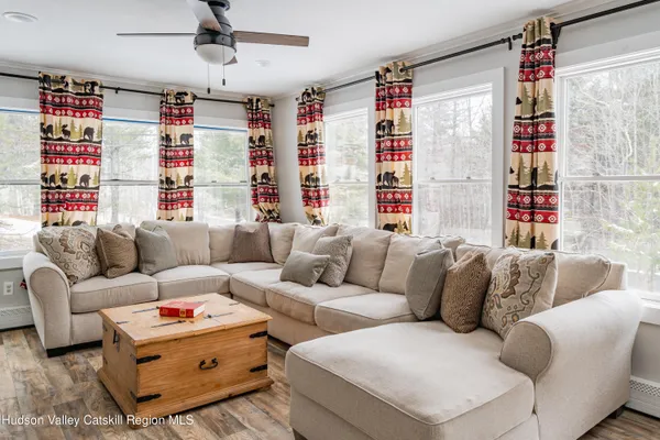 a living room with furniture a large window and a couch