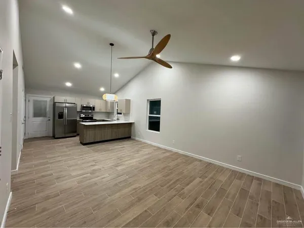 a view of a kitchen with a sink and a refrigerator