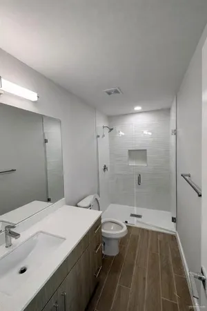 a bathroom with a sink a toilet and shower