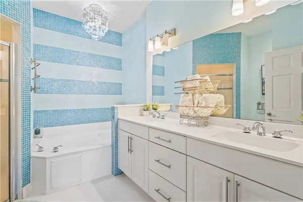a bathroom with a tub sink and mirror