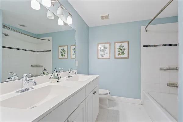 a bathroom with a sink a toilet a shower and a mirror