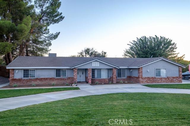 a front view of a house with a garden and trees