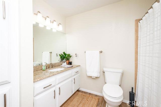 15222 Riverside Drive Apple Valley, CA 92307 - Photo 15 of 43 a bathroom with a granite countertop toilet sink and mirror