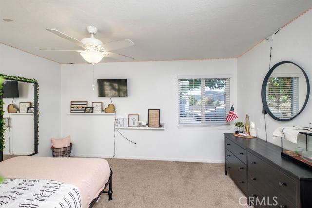 15222 Riverside Drive Apple Valley, CA 92307 - Photo 17 of 43 a bedroom with a large bed and a chandelier